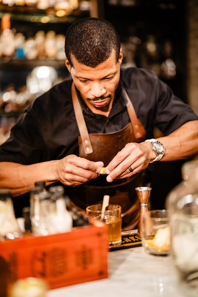 Bartender close up leather apron crafting cocktail at Urban Stillhouse wedding St Pete by Ying Multimedia
