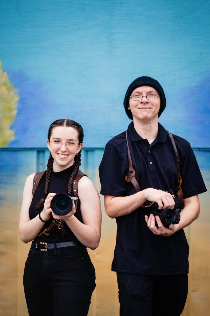 Mariah and James, associate wedding photographers at Ying Multimedia, holding cameras at Mixon Farms Bradenton Florida