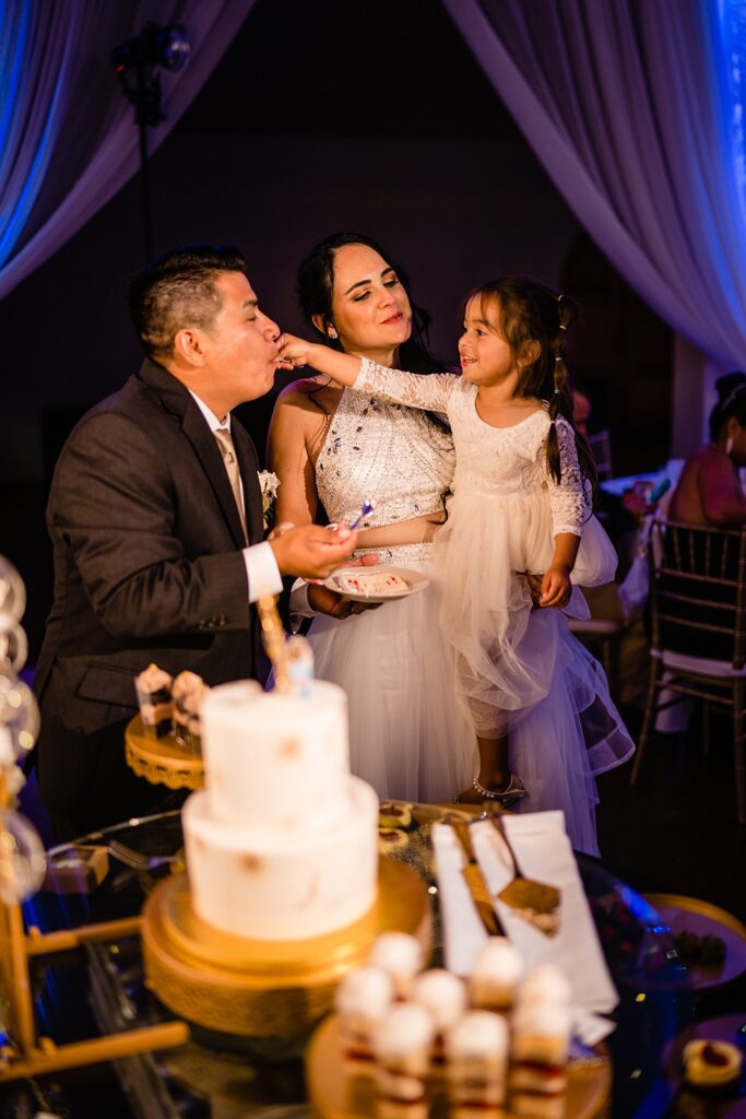 Daughter feeding cake to Jorge at Bakers Ranch wedding reception by Ying Multimedia