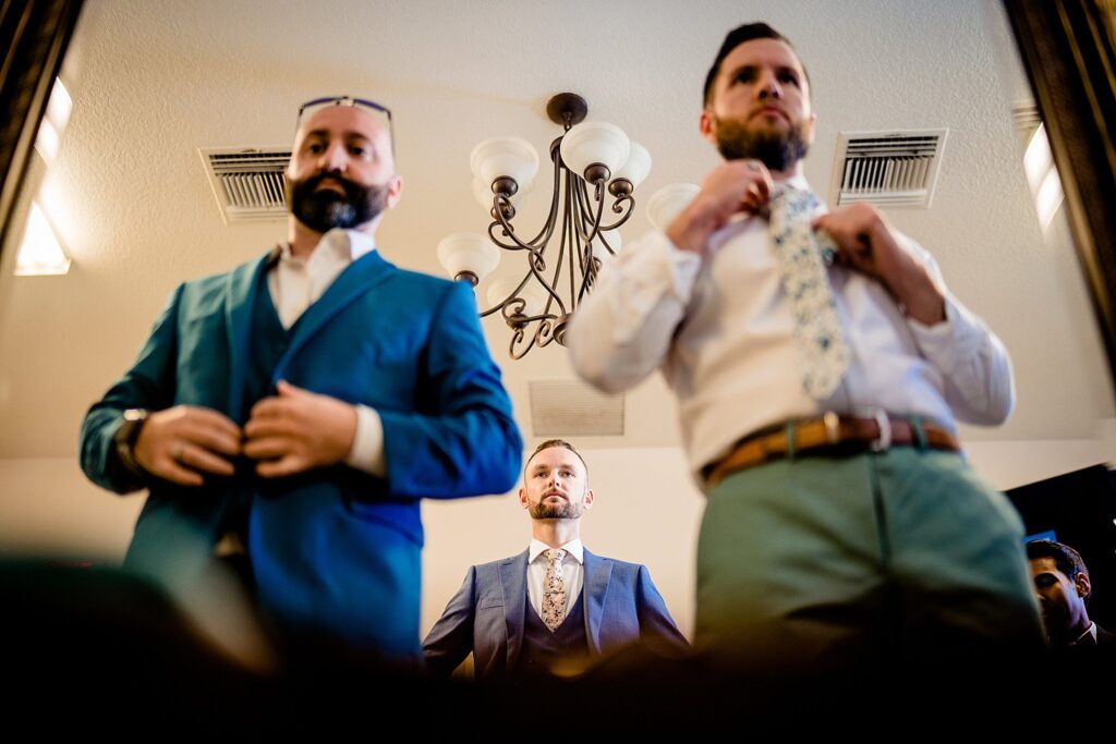 Groom and groomsmen getting dressed in the groom's suite at The Pavilion at Mixon Farms