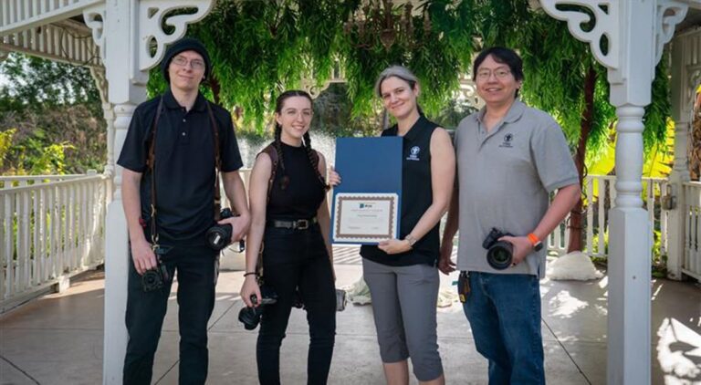 The Ying Multimedia team holding the First Harvest Vendor award certificate at the gazebo at The Pavilion at Mixon Farms
