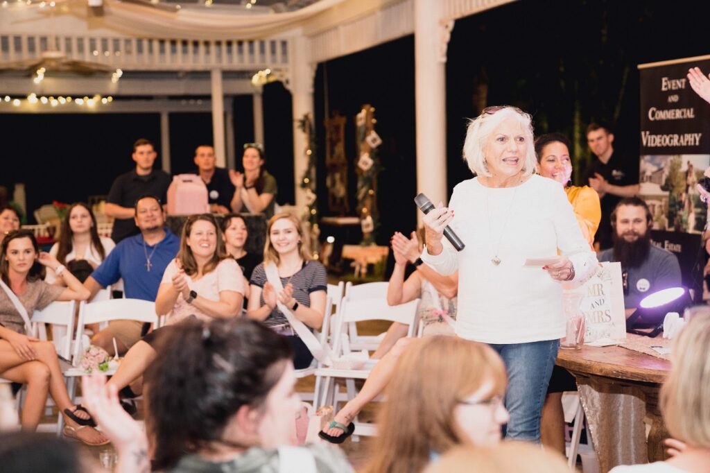 Janet Mixon speaking to a crowd at a bridal show at The Pavilion at Mixon Farms during a free wedding giveaway