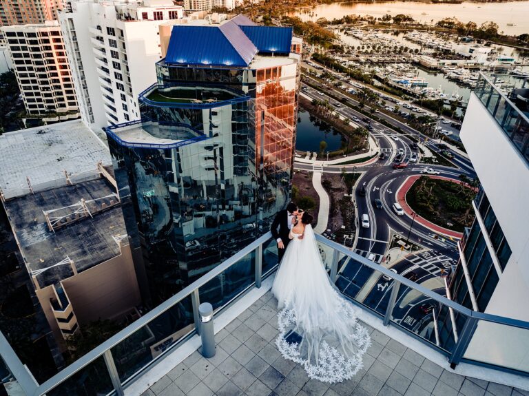 Aerial view of bride and groom kissing on a high rise balcony overlooking Sarasota