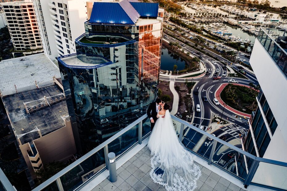 Aerial view of bride and groom kissing on a high rise balcony overlooking Sarasota