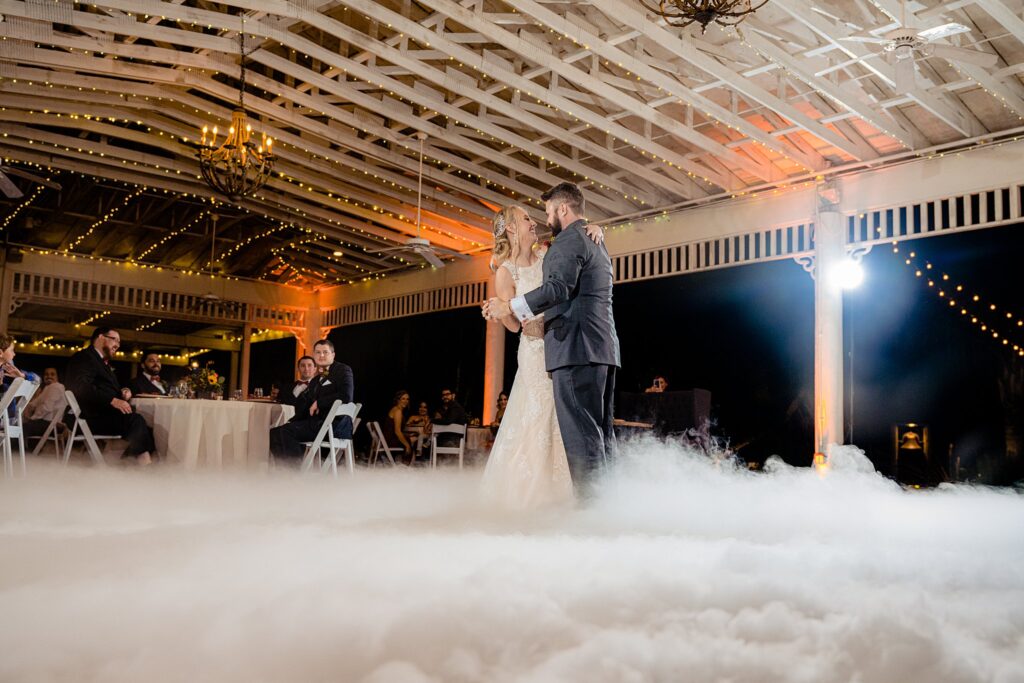 Bride and groom sharing their first dance on a low fog dance floor inside the pavilion at The Pavilion at Mixon Farms
