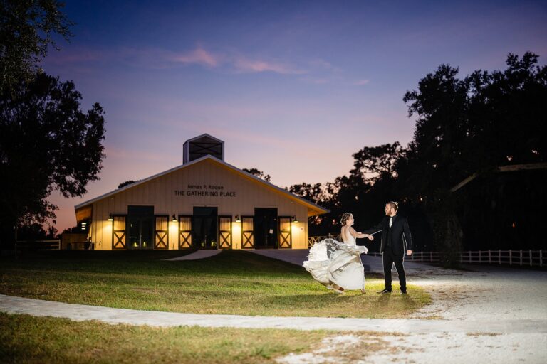 Bride and groom dancing at dusk in front of The Gathering Place at The Retreat Sarasota