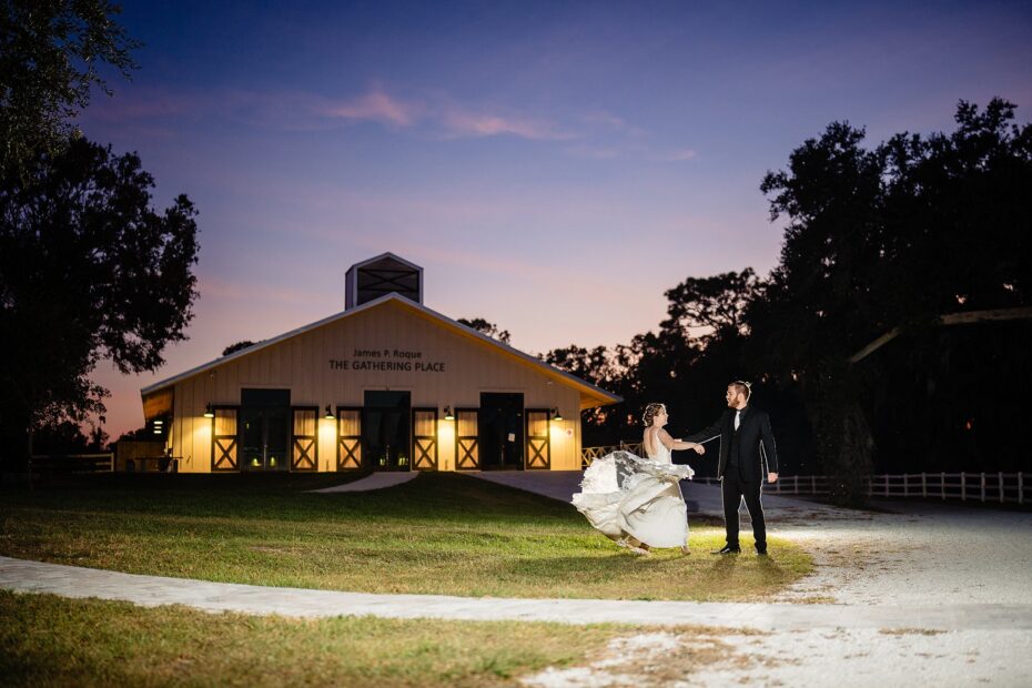 Bride and groom dancing at dusk in front of The Gathering Place at The Retreat Sarasota